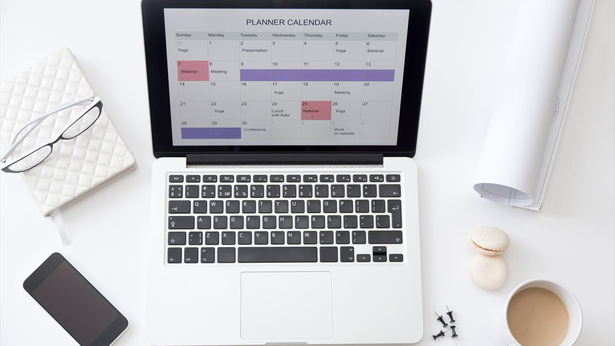 Notebook com um calendário de planejamento na tela, sobre uma mesa de trabalho