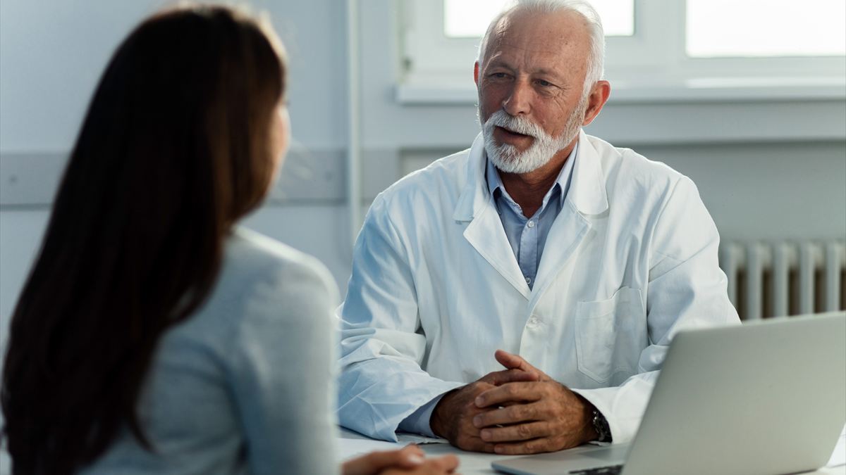 Médico conversando com uma paciente no consultório