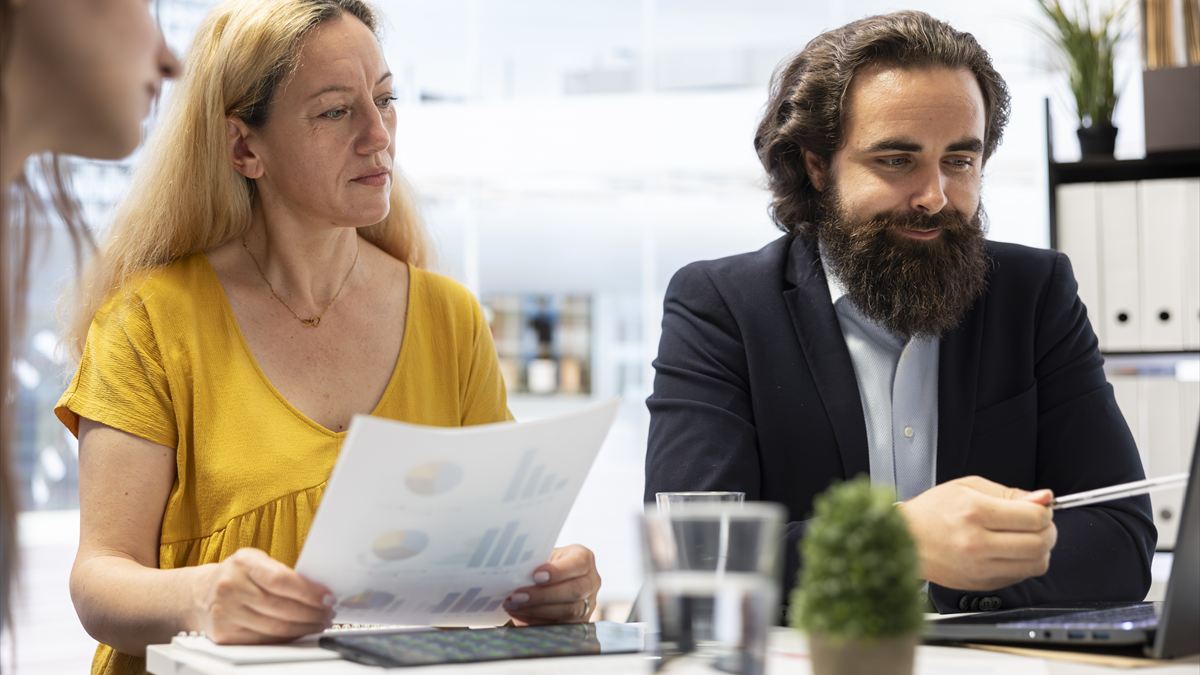 Consultor apresentando um relatório para uma cliente no escritório